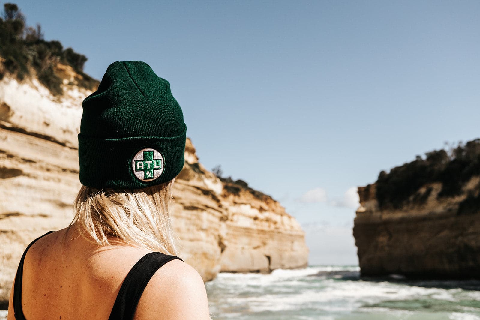 Girl Wearing an Atlrx Cap Standing by a Sunny Riverside